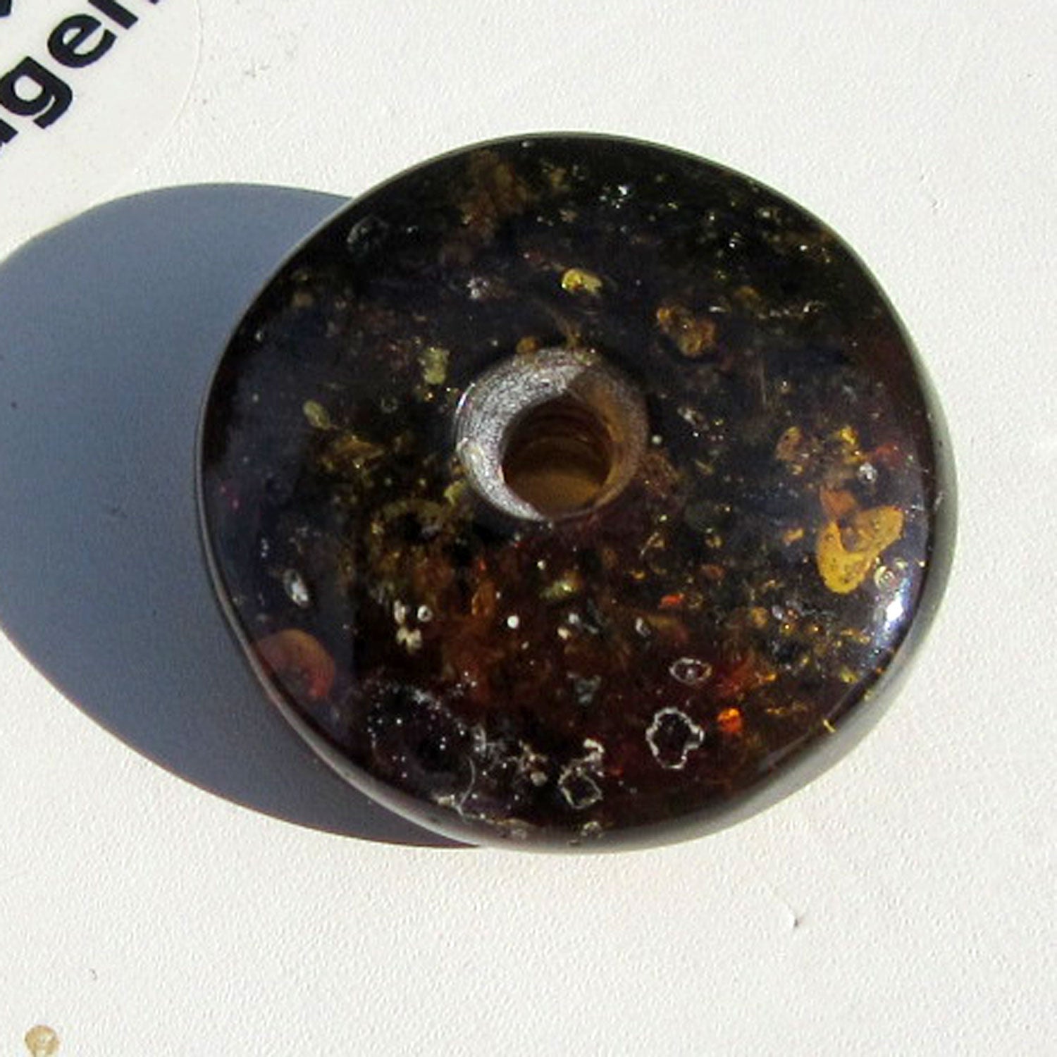 Dunkler Bernsteindonut mit Einschlüssen, rund geschliffen