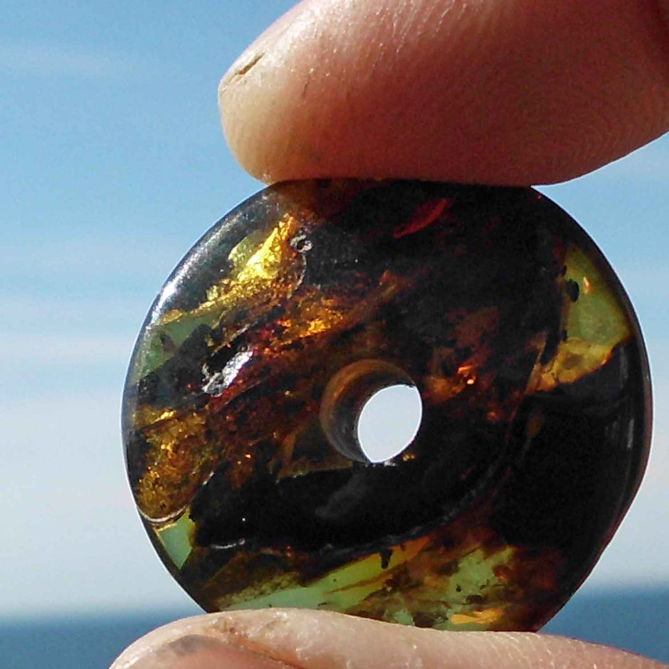 Polierter Bernsteindonut mit natürlichen Einschlüssen