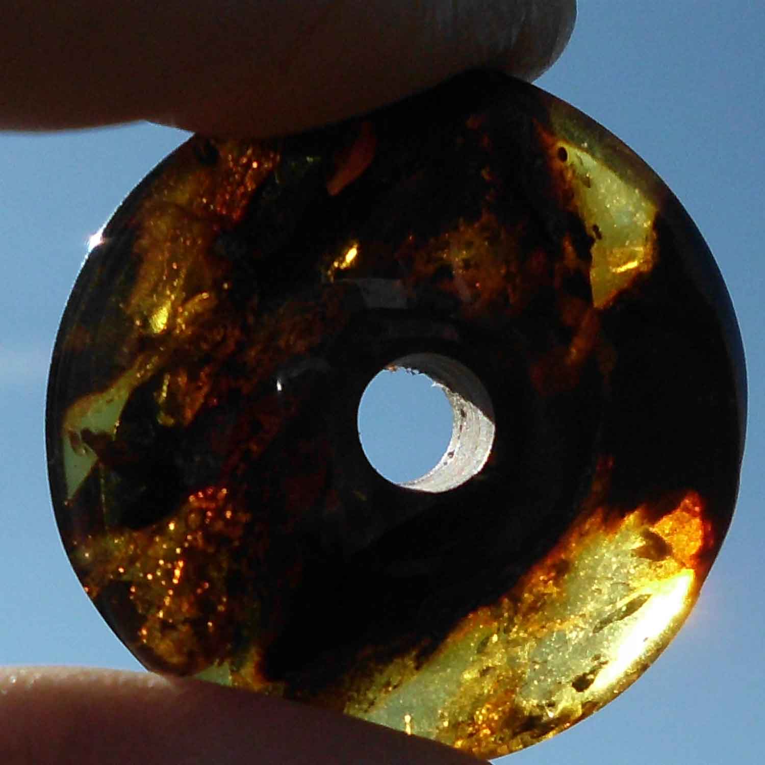 Polierter Bernsteindonut mit natürlichen Einschlüssen