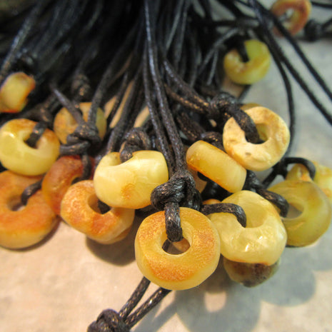 Bernsteindonut am Baumwollband, unpoliert, Einzelstück