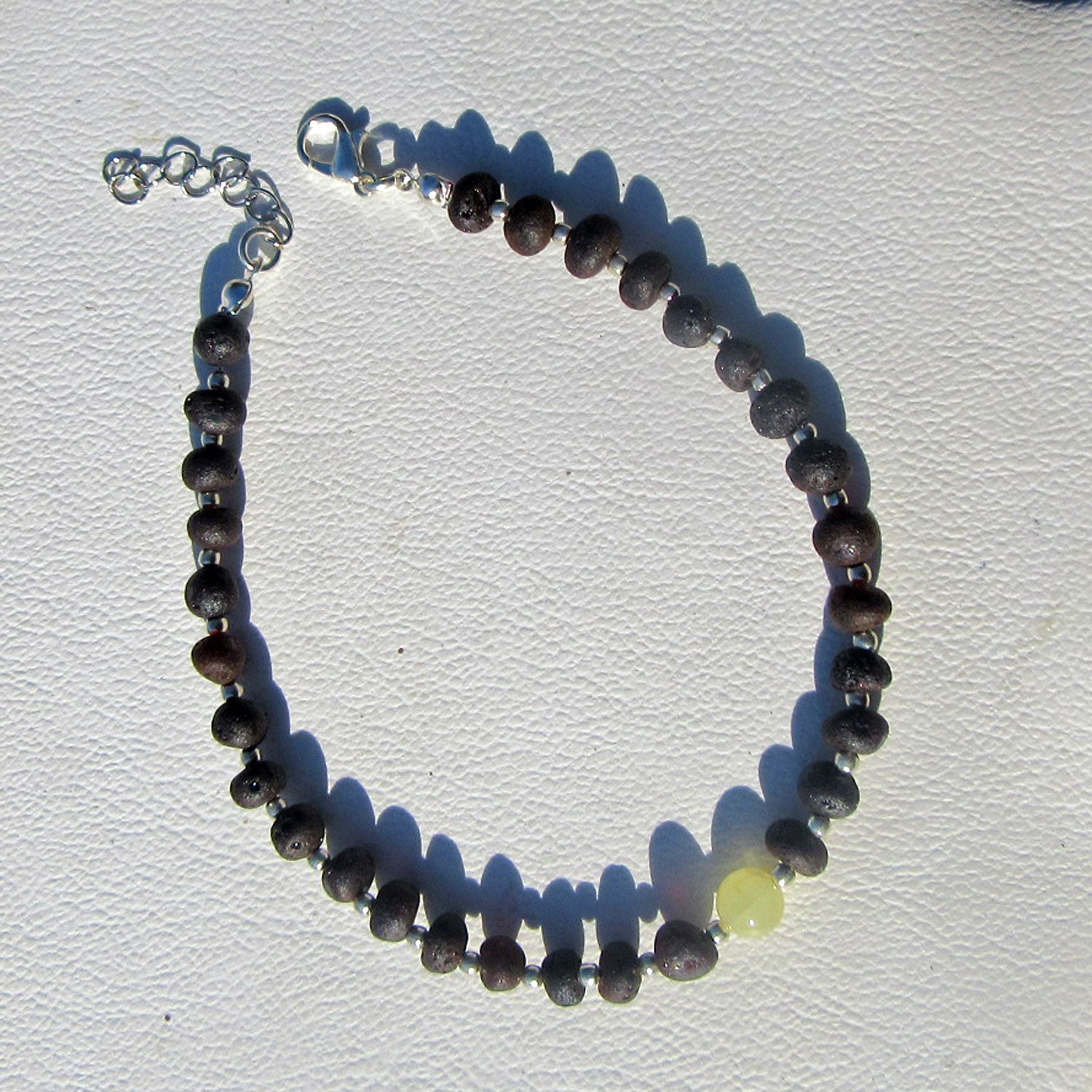 Fusskettchen aus dunklem Bernstein mit heller Perle