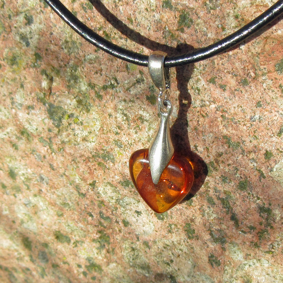 Kognacfarbenes Bernsteinherz mit Silberverzierung