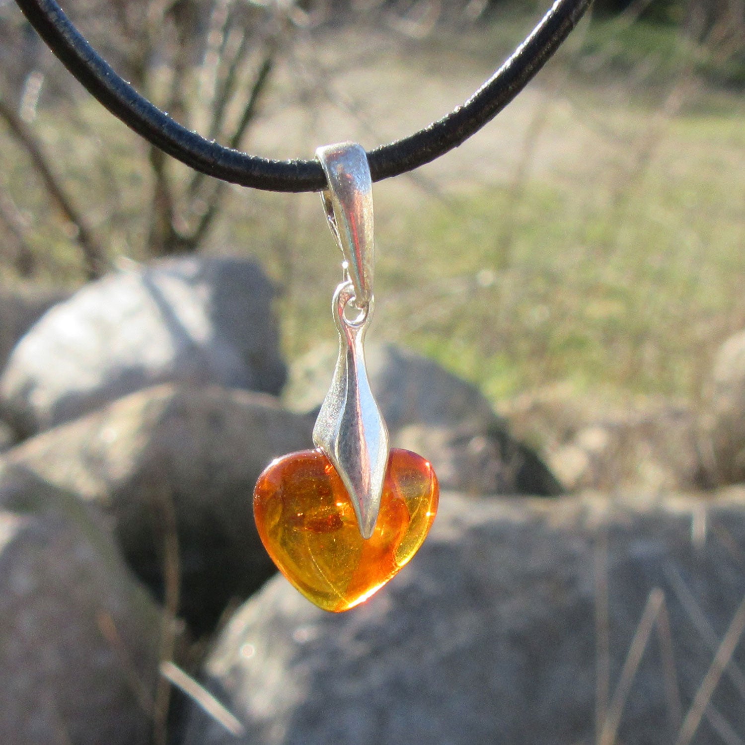 Kognacfarbenes Bernsteinherz mit Silberverzierung