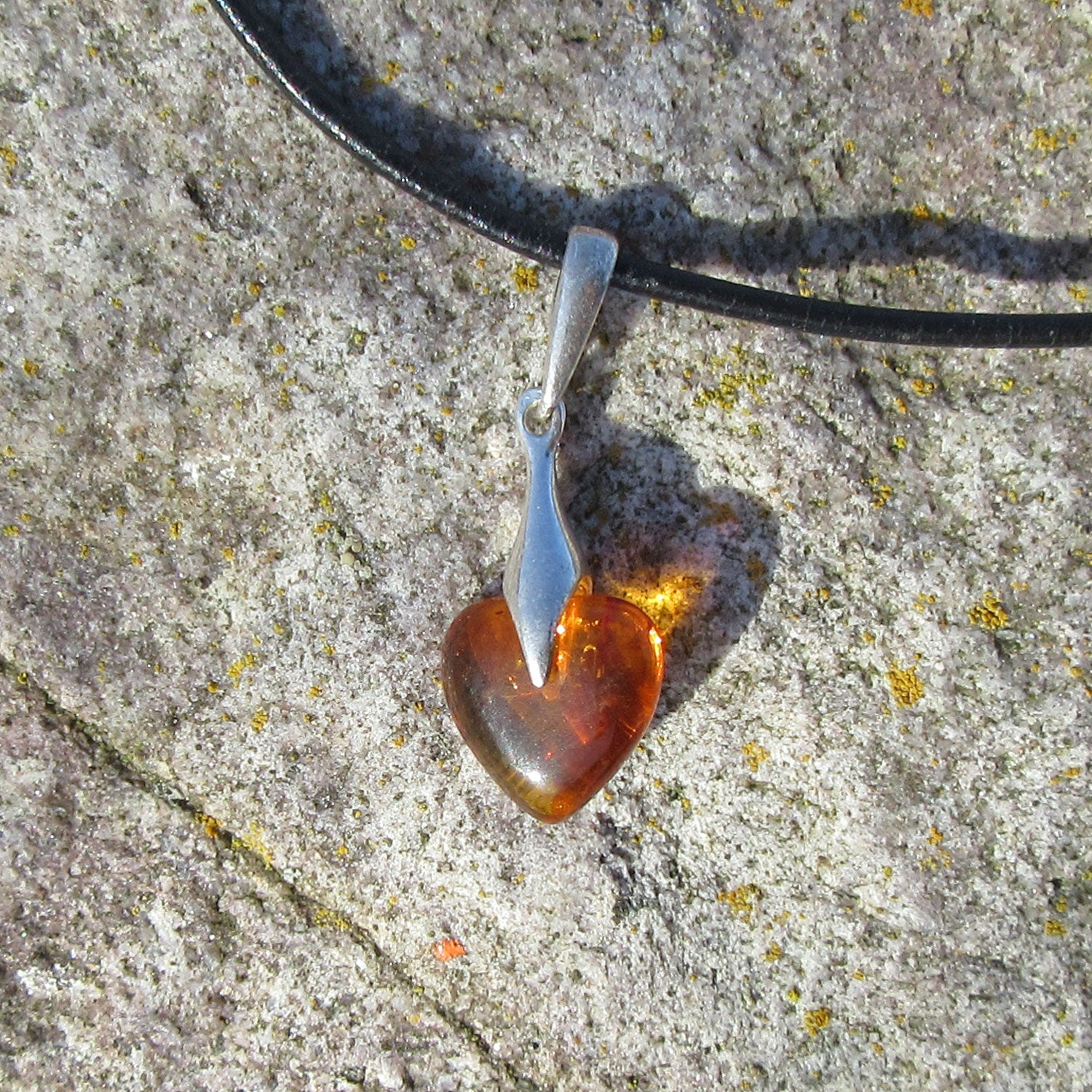 Kognacfarbenes Bernsteinherz mit Silberverzierung