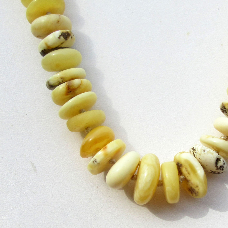 Bernsteinkette aus weissen/elfenbeinfarbenen Scheibchen, mit Einschlüssen