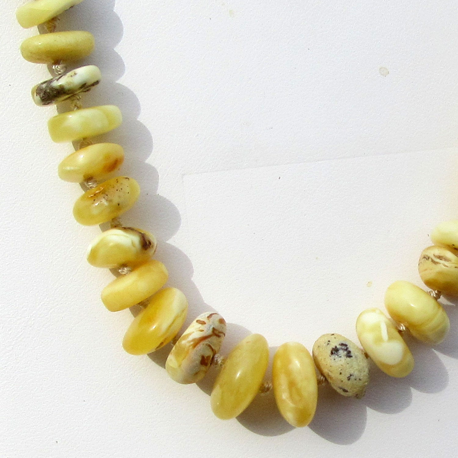 Bernsteinkette aus weißen Scheibchen mit Einschlüssen