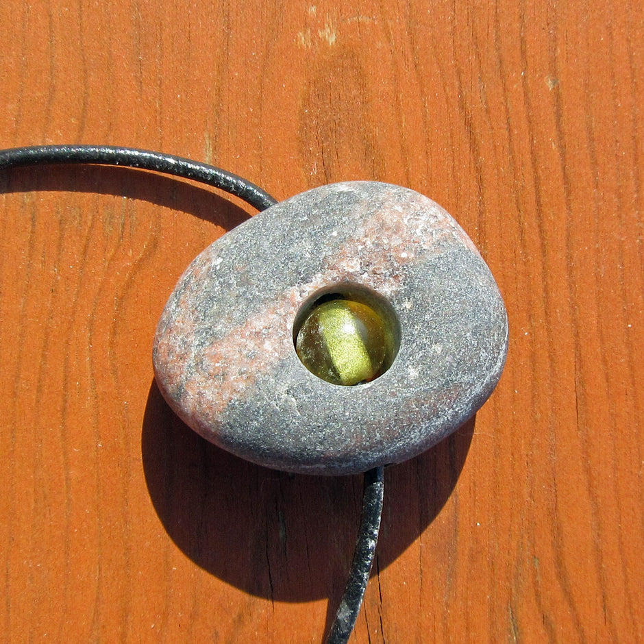 Kleine Bernsteinperle im unpolierten Kiesel von Rügen