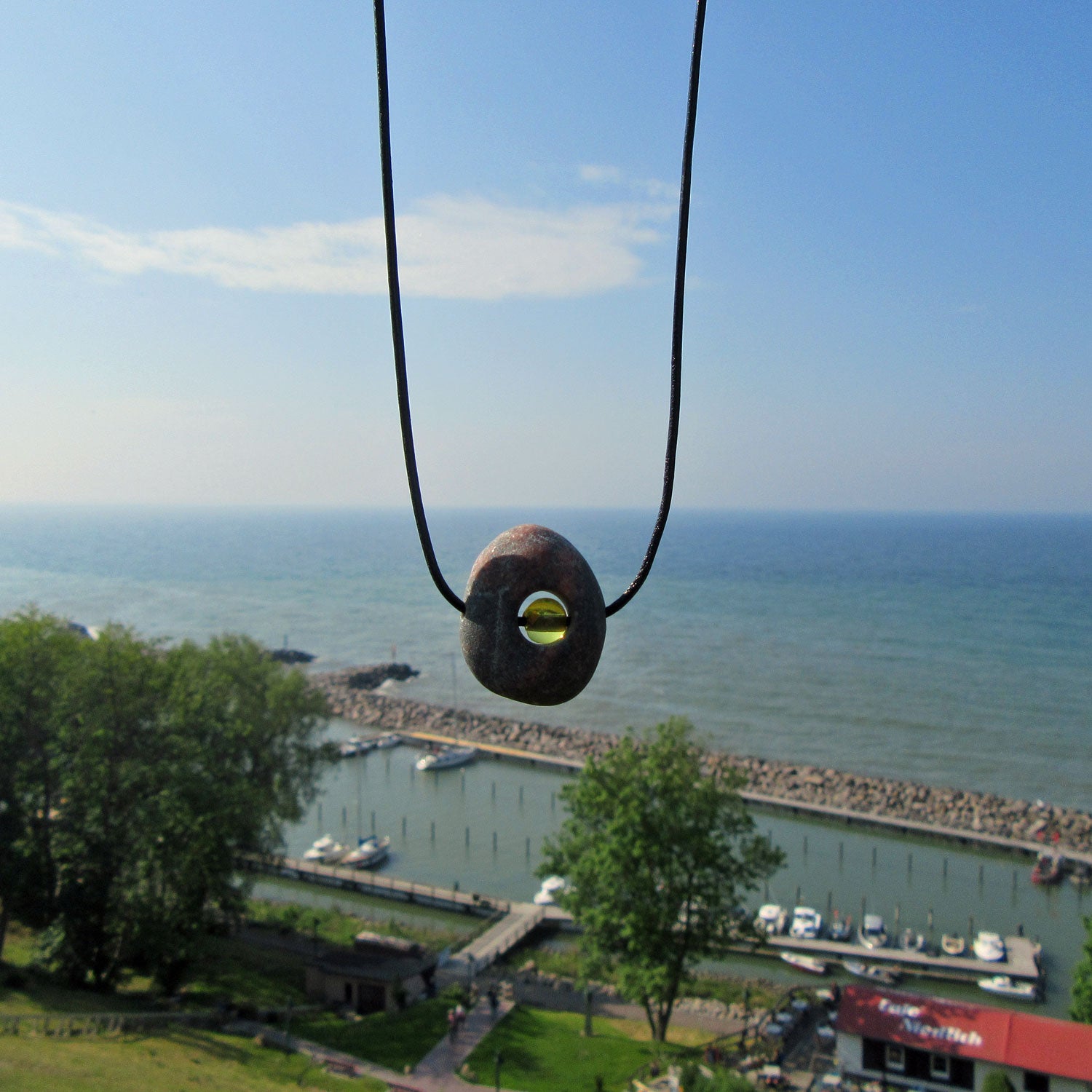 Kleine Bernsteinperle im unpolierten Kiesel von Rügen