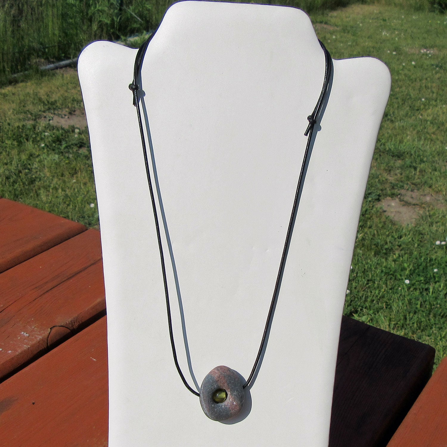 Kleine Bernsteinperle im unpolierten Kiesel von Rügen