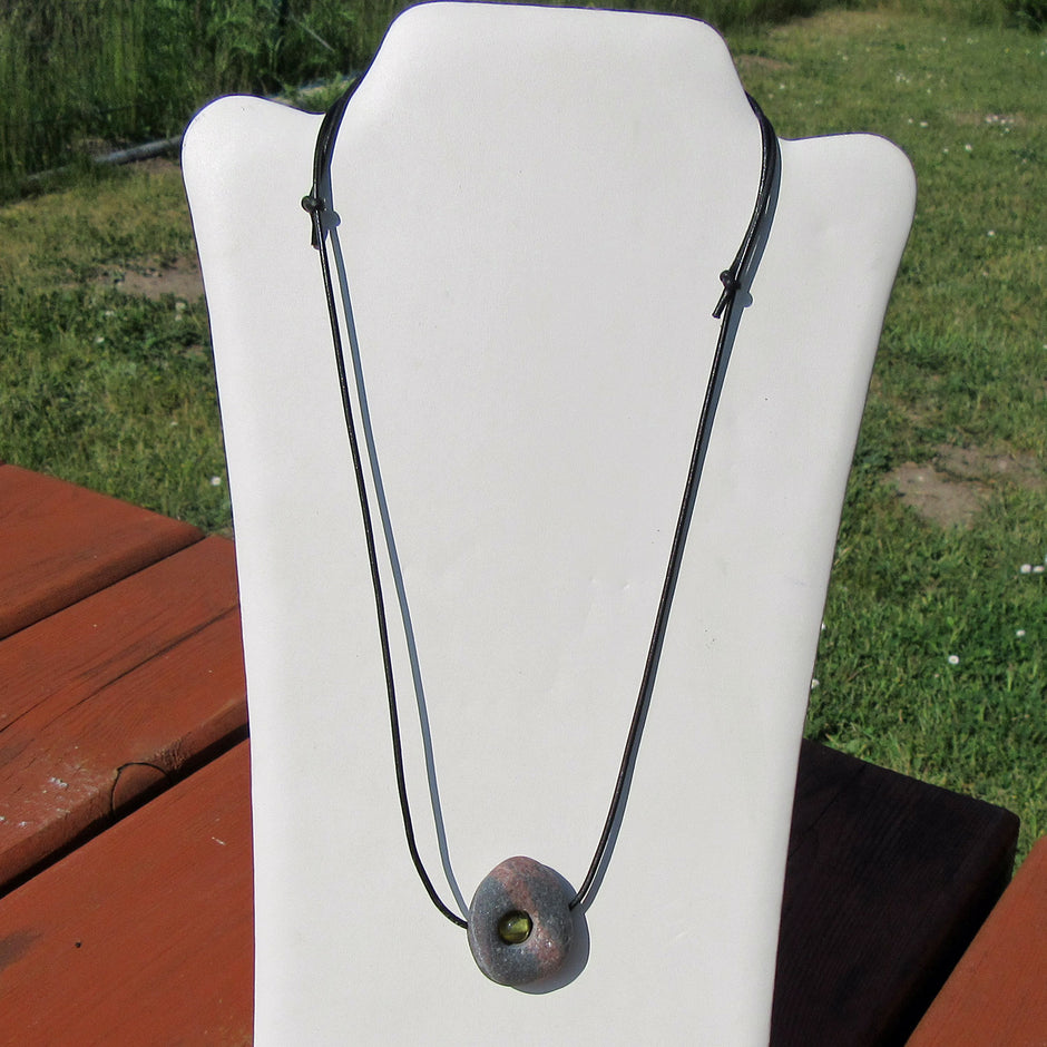 Kleine Bernsteinperle im unpolierten Kiesel von Rügen