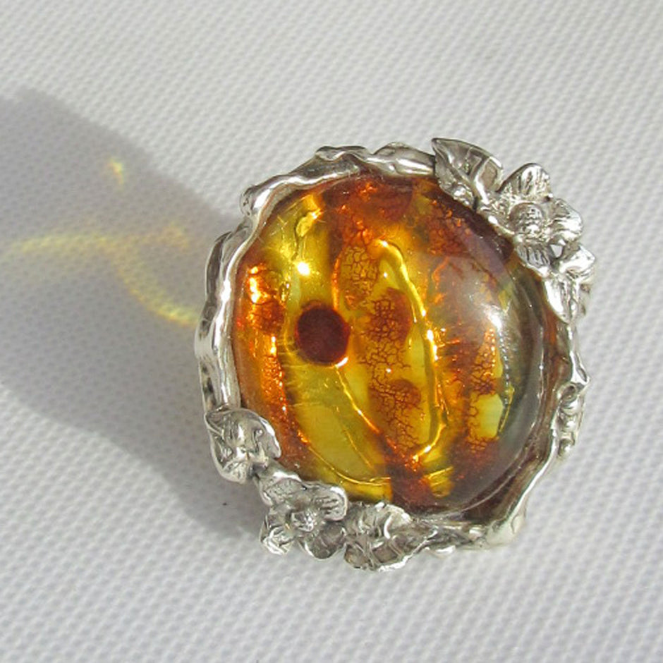 Mit Blumen und Blättern verzierter Fingerring aus Silber und schönem, goldgelben Bernstein