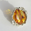 Mit Blumen und Blättern verzierter Fingerring aus Silber und schönem, goldgelben Bernstein
