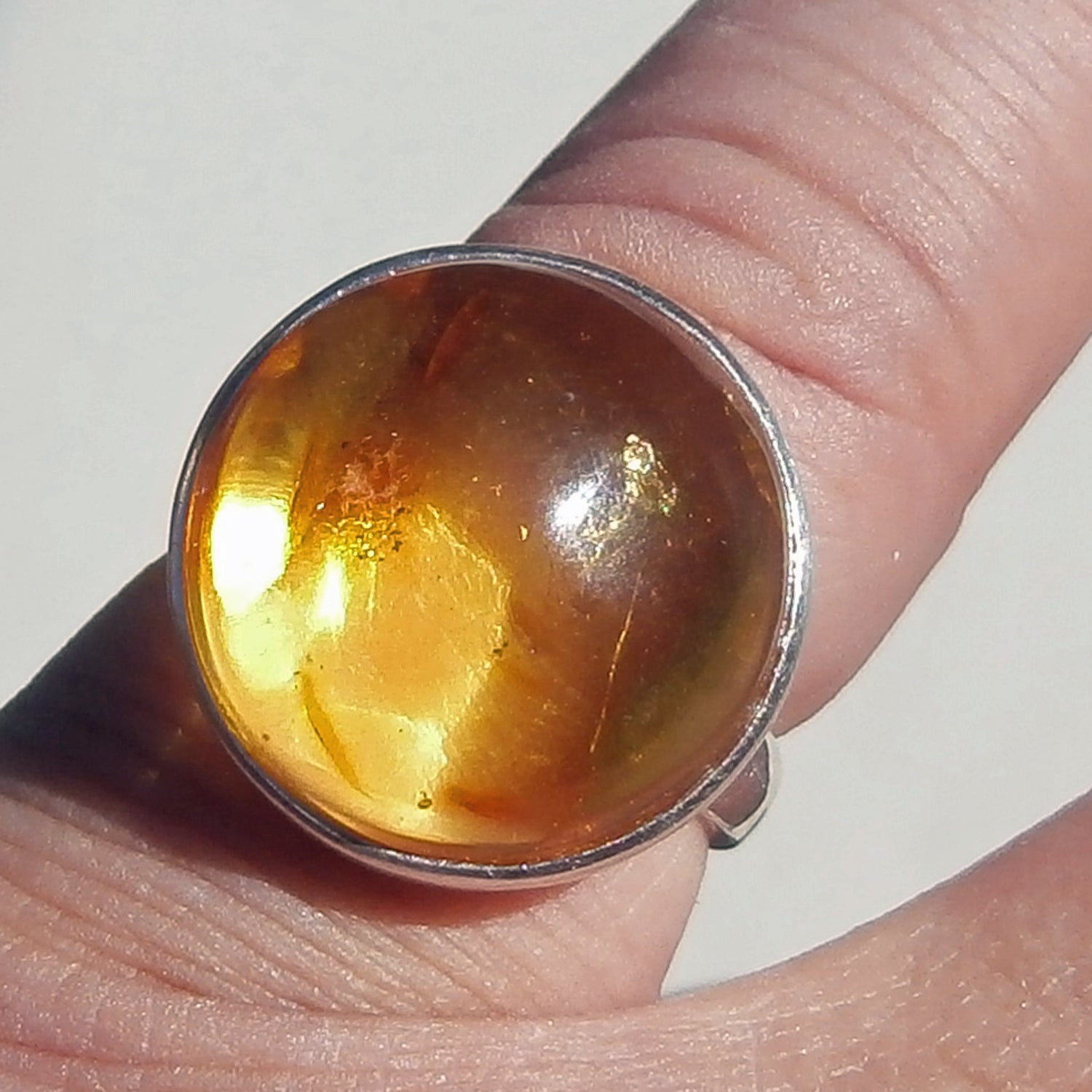 Runder Fingerring aus sonnenfarbenem Bernstein und Silber