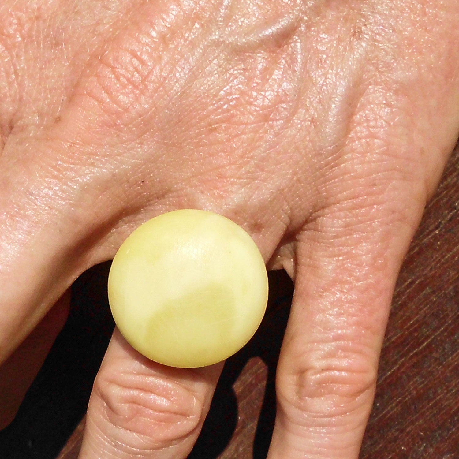 Runder, polierter Bernstein in Silberfassung – Unikat