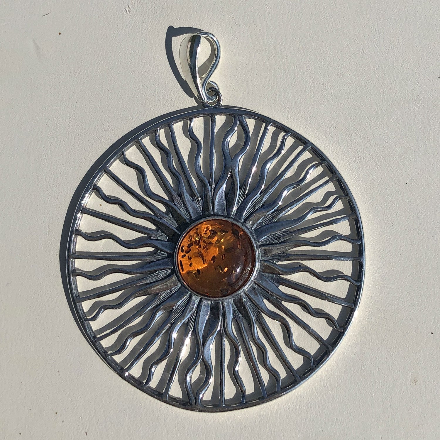Edler Anhänger als Sonne aus Silber mit kognacfarbenem Bernstein, mit kleinen Einschlüssen