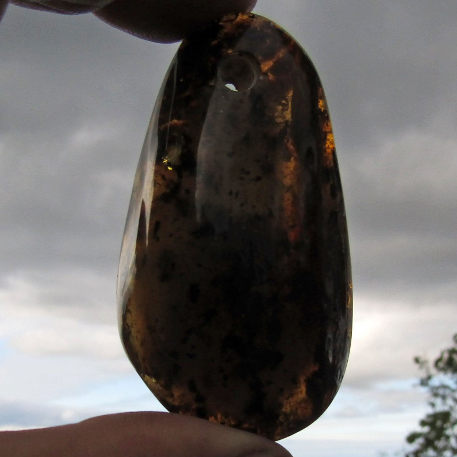 Dunkles Bernsteinstück, poliert und gebohrt, Unikat