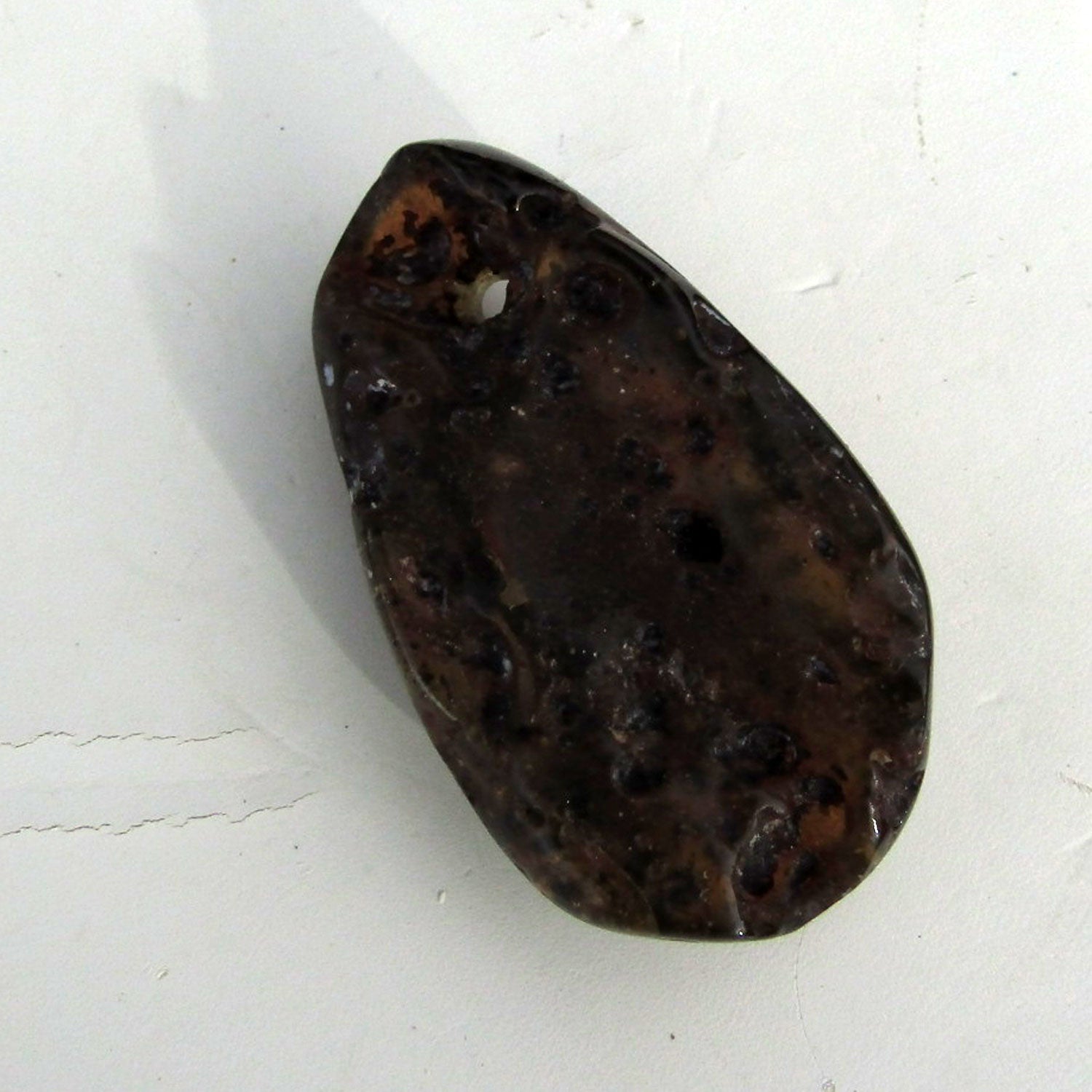 Dunkles Bernsteinstück, poliert und gebohrt, Unikat