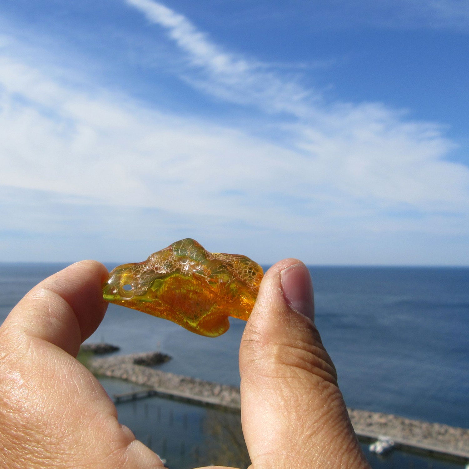 Einzelstück: Geschliffenes, grünes Bernsteinstück mit Bohrung