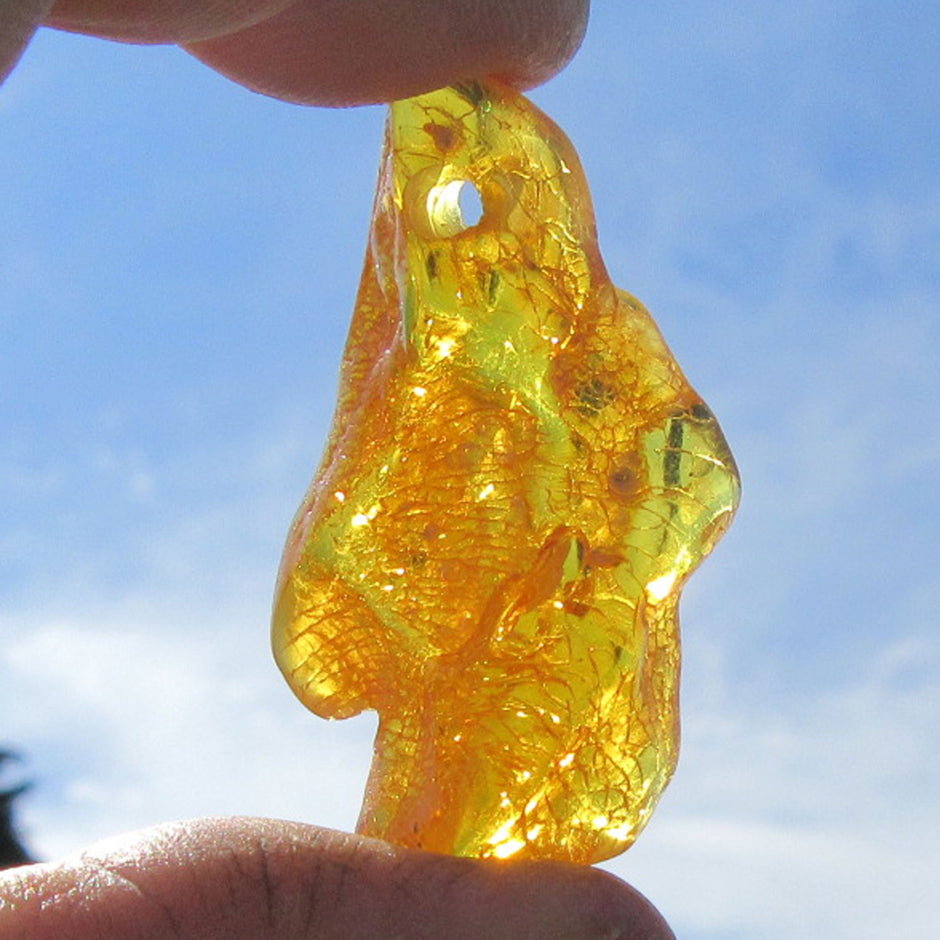 Einzelstück: Geschliffenes, grünes Bernsteinstück mit Bohrung