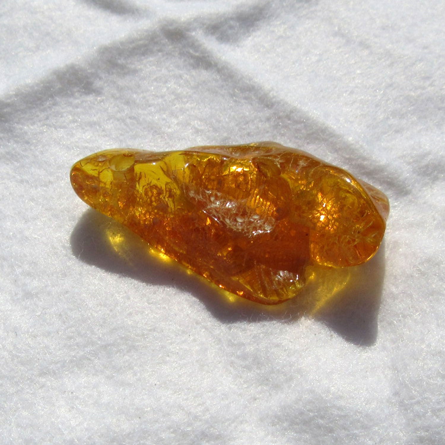 Einzelstück: Geschliffenes, grünes Bernsteinstück mit Bohrung