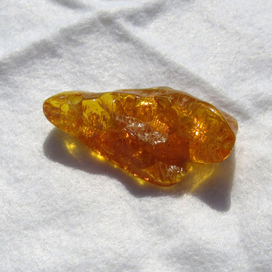 Einzelstück: Geschliffenes, grünes Bernsteinstück mit Bohrung