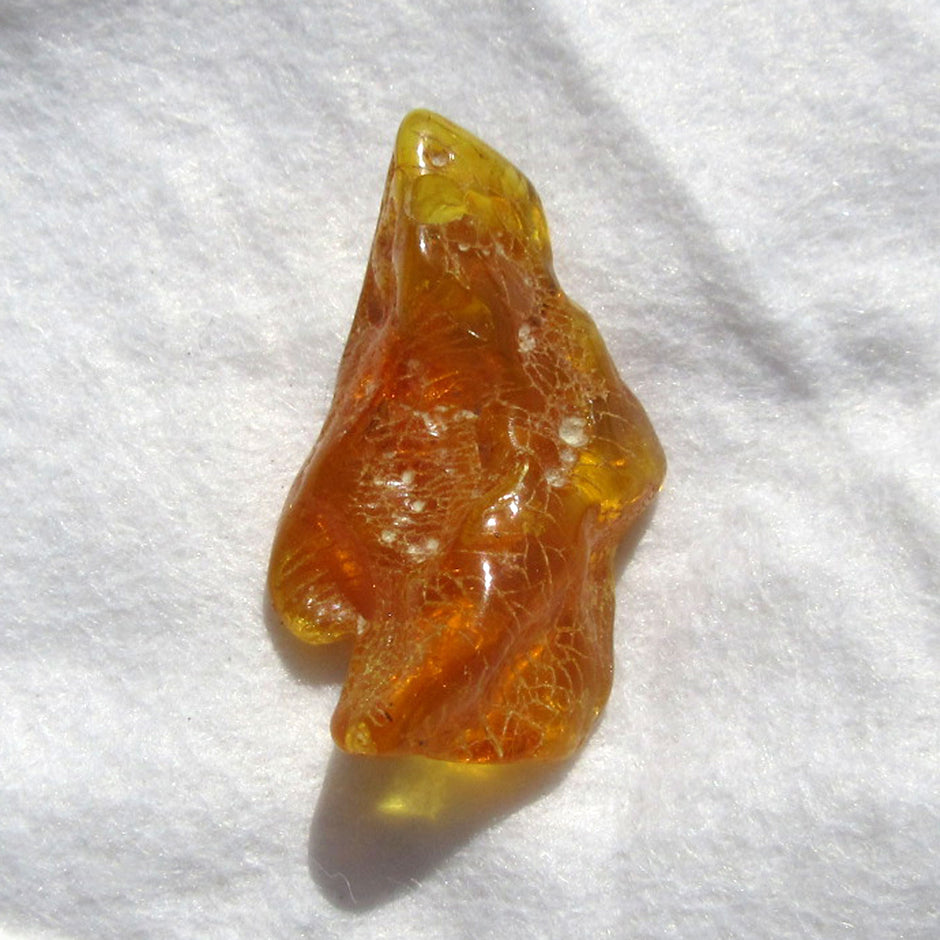 Einzelstück: Geschliffenes, grünes Bernsteinstück mit Bohrung