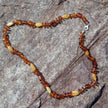 Lange Kette aus flachen und olivenförmigen Bernsteinen