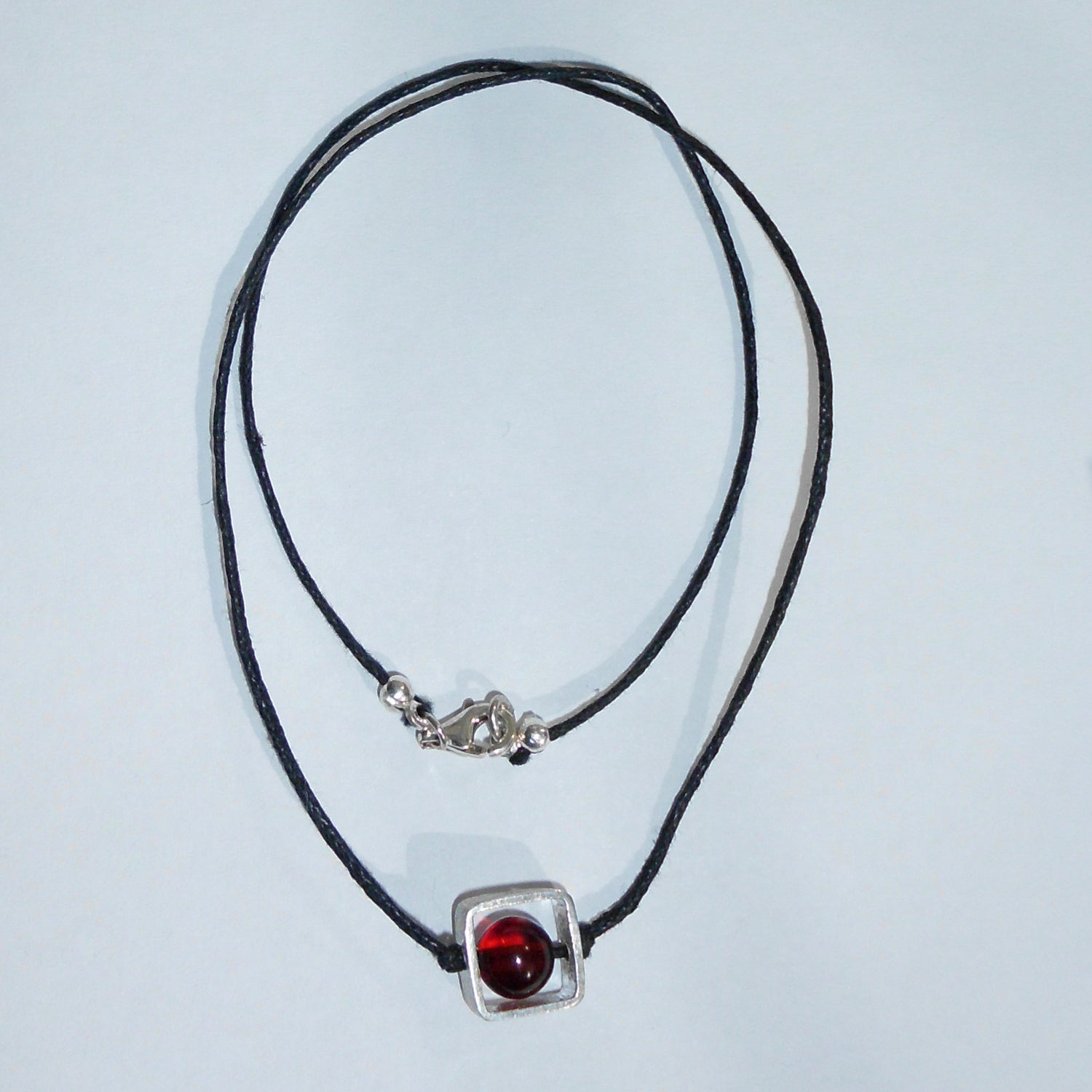 Collier mit Bernsteinperle im Silberquadrat, Unikat