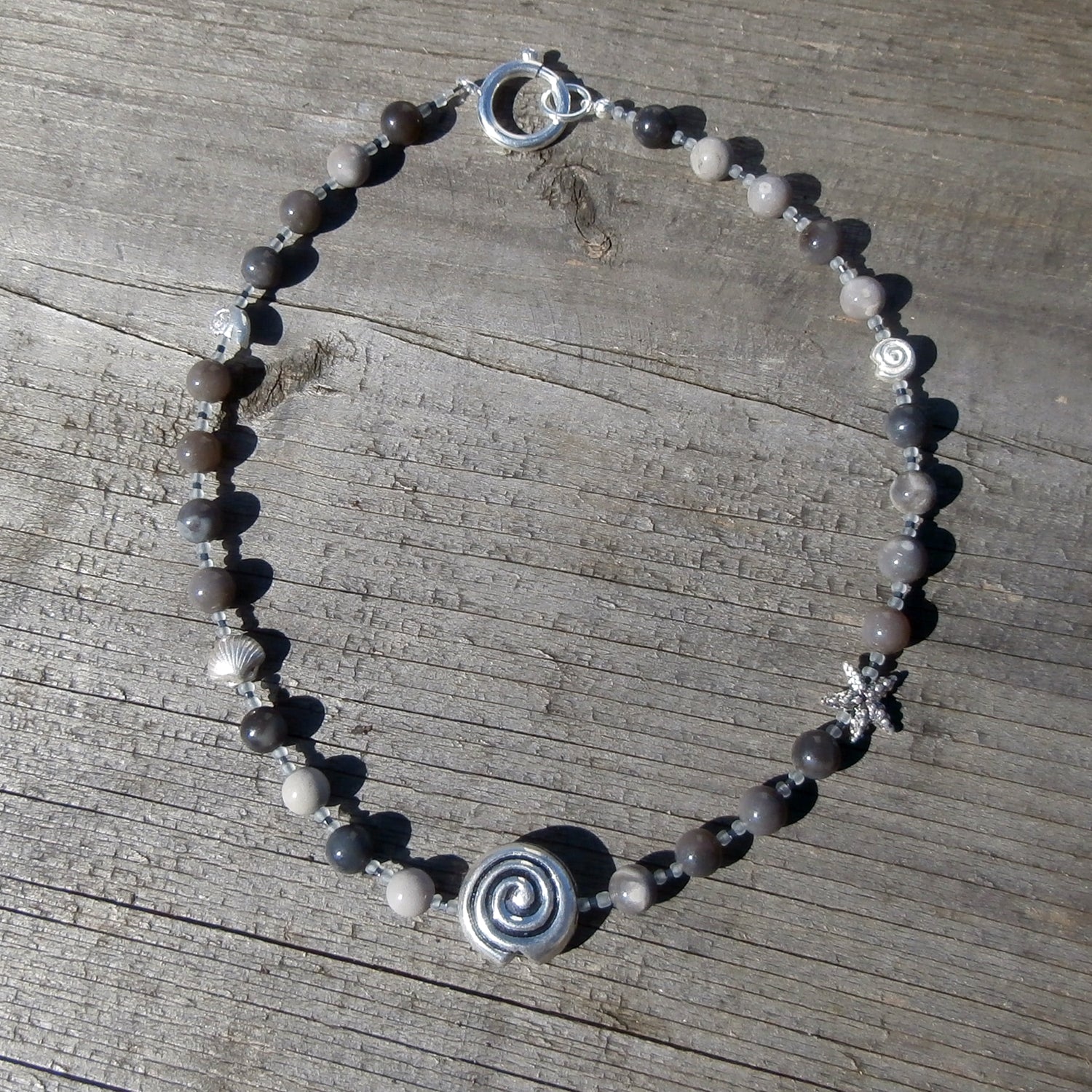 Collier aus fein polierten, verschiedenfarbigen Feuersteinperlen mit maritimen Silbermotiven