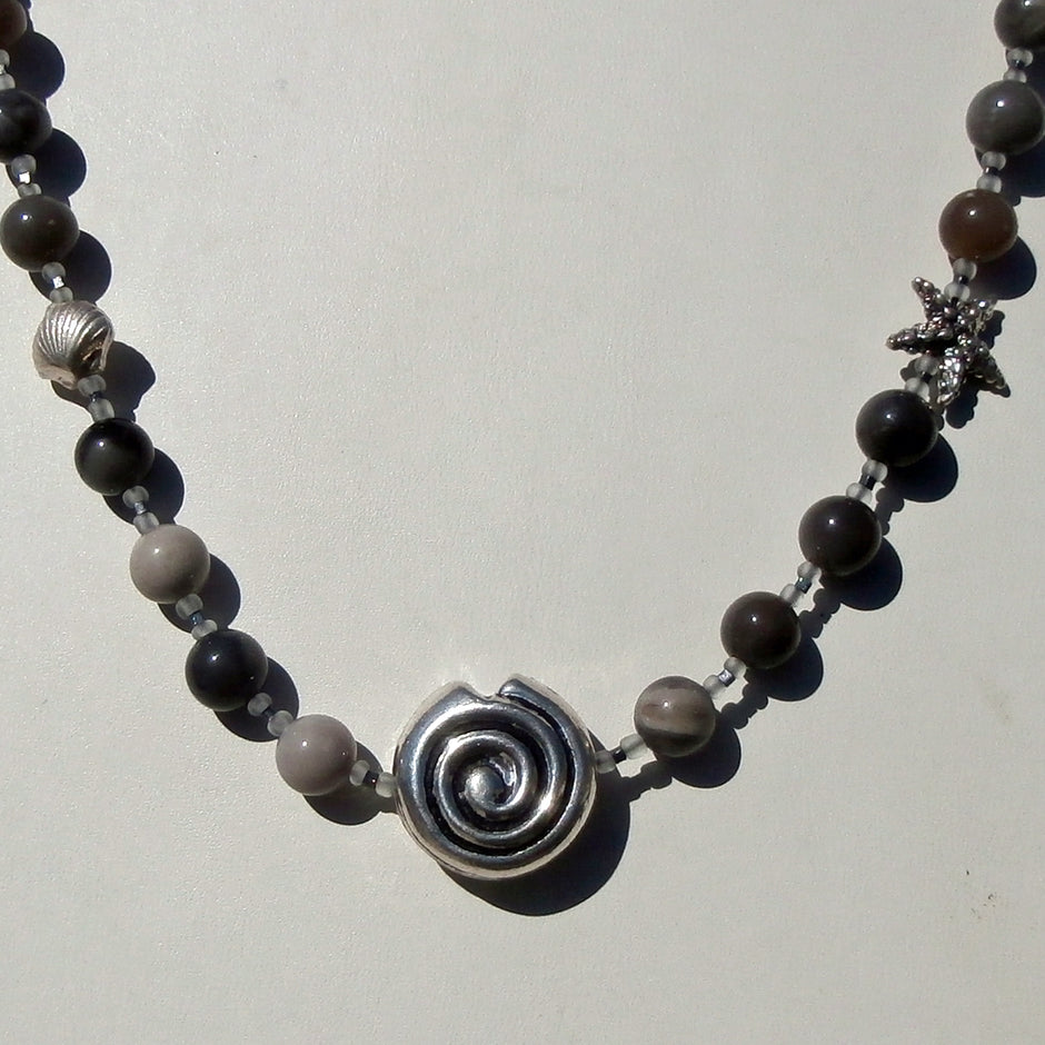 Collier aus fein polierten, verschiedenfarbigen Feuersteinperlen mit maritimen Silbermotiven