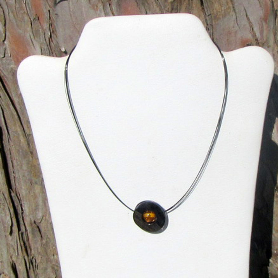 Edelstahlscheibe mit Bernsteinperle am Drahtcollier