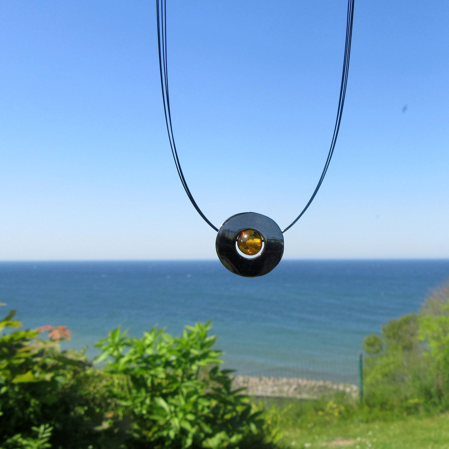 Edelstahlscheibe mit Bernsteinperle am Drahtcollier