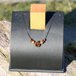 Collier aus Bernstein in dunklem Holzring – Einzelstück
