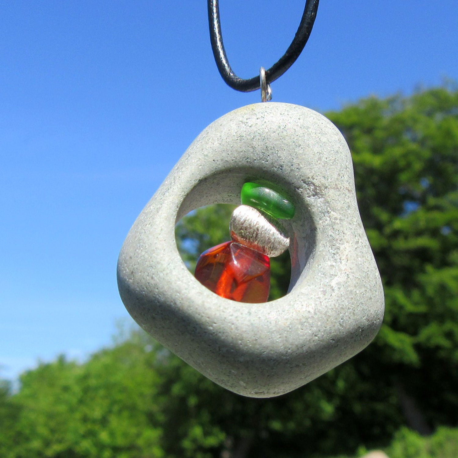 Bernsteinperle mit Seeglas und Silber im Kiesel von Rügen