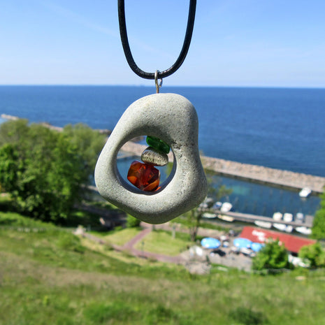 Bernsteinperle mit Seeglas und Silber im Kiesel von Rügen