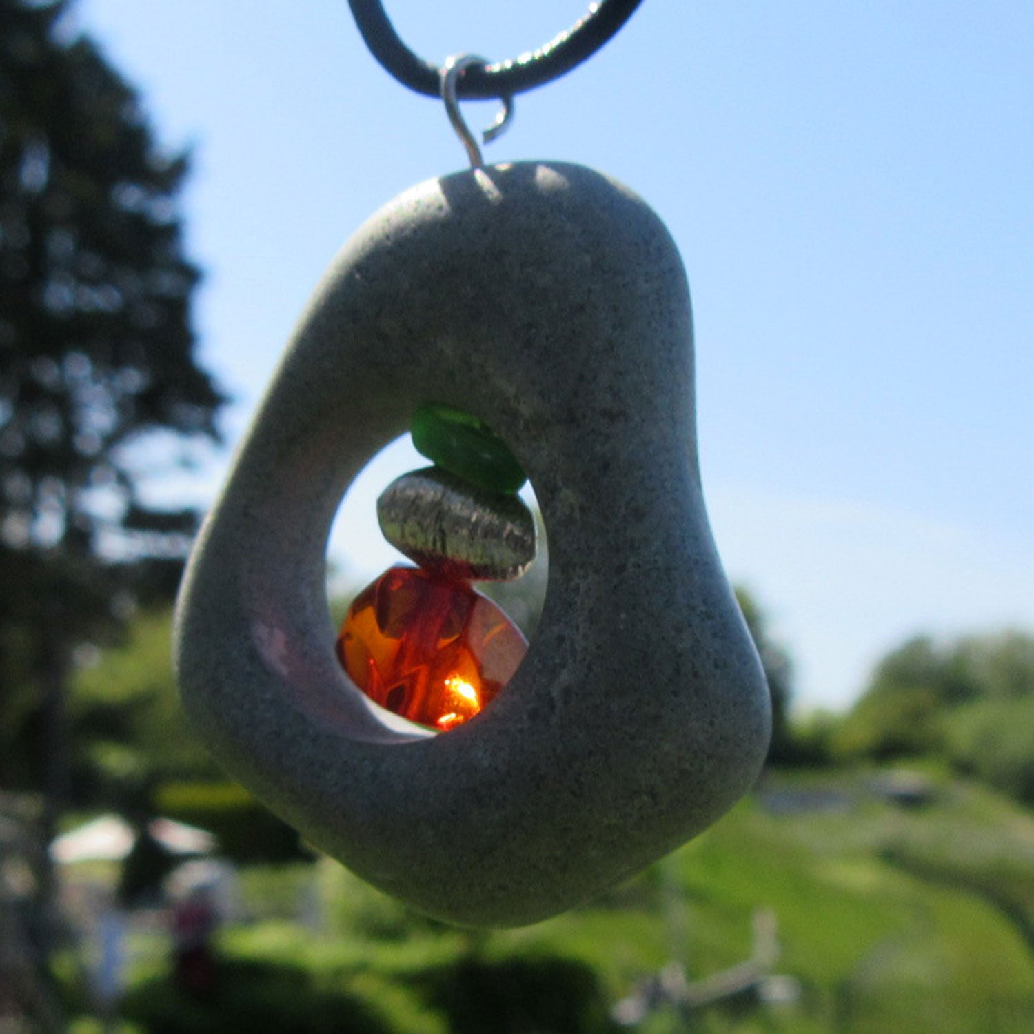 Bernsteinperle mit Seeglas und Silber im Kiesel von Rügen