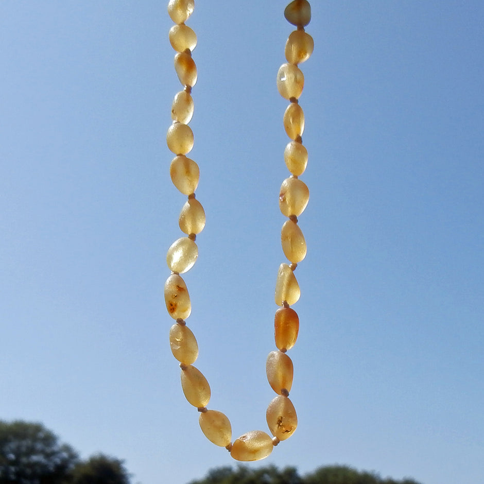 Zahnungskette in Olivenform aus unpoliertem Bernstein