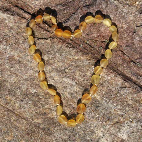 Zahnungskette in Olivenform aus unpoliertem Bernstein