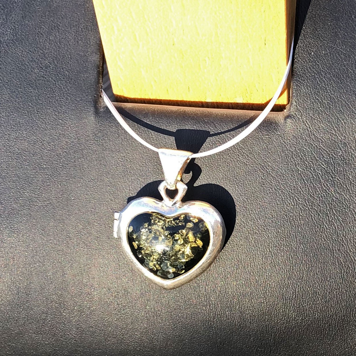 Aufklappbares Amulett in Herzform mit grünem Bernstein