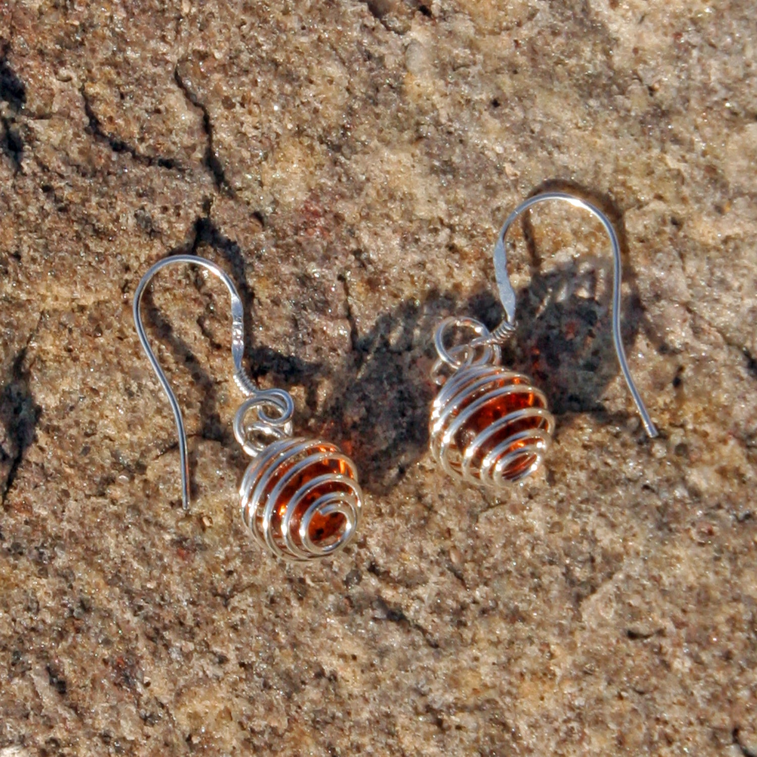 Kleine Ohrhänger aus Bernstein in silberfarbener Spirale