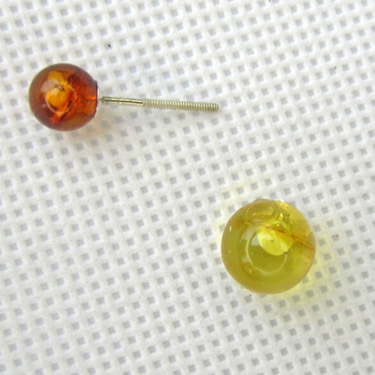 Ohrstecker mit einer grossen hellen und einer kleinen kongnacfarbenen Perle aus Bernstein