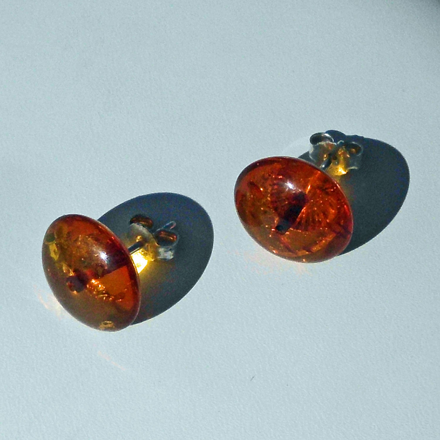 Silberne Ohrstecker mitpolierten, kognacfarbenenBernsteinscheiben