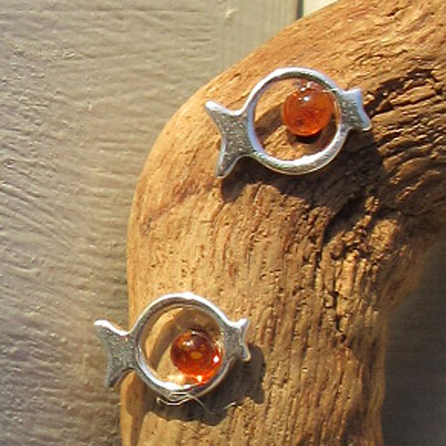 Silberne Ohrstecker in Fischform mit Bernsteinperle