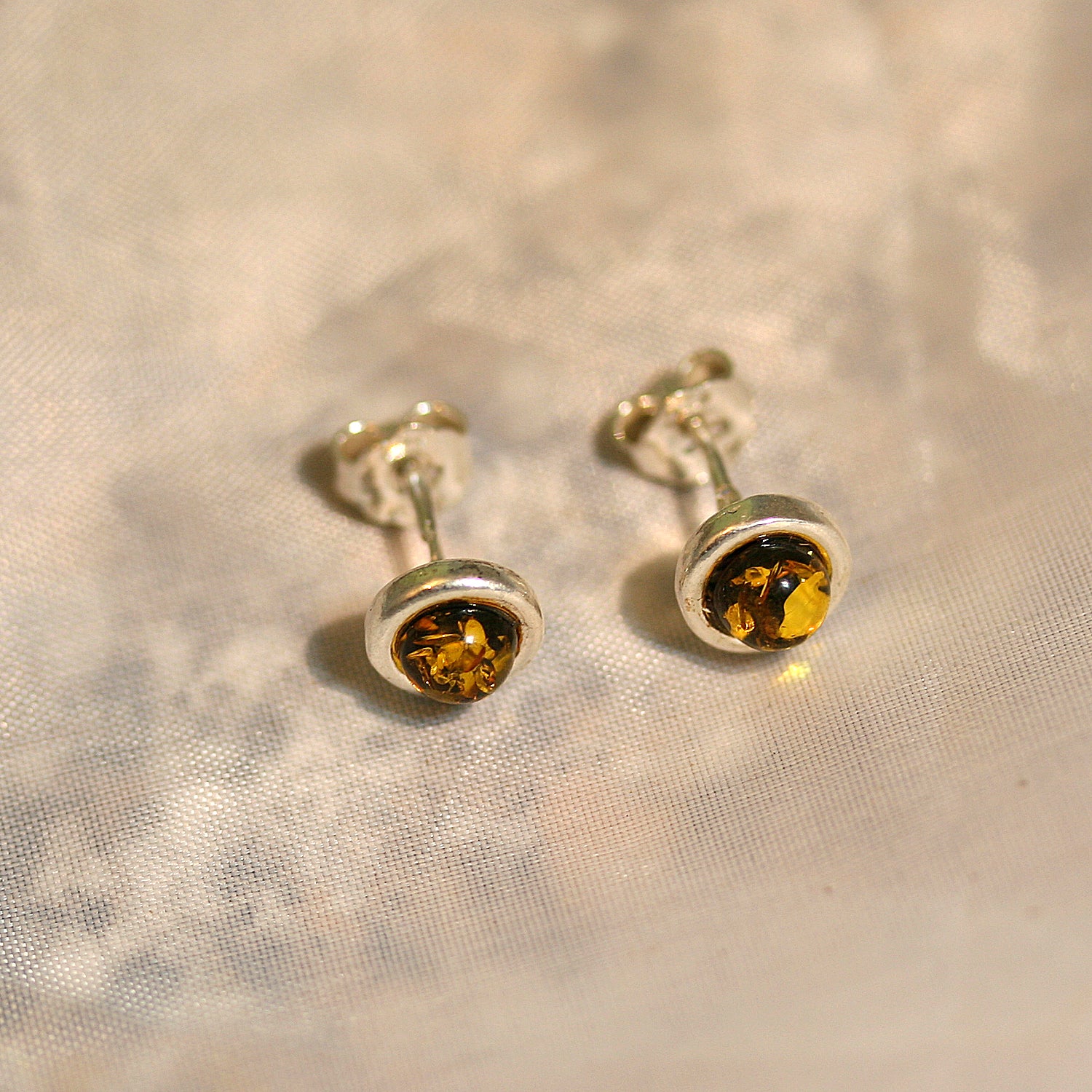 Runde Ohrstecker aus Bernstein in Silber gefasst