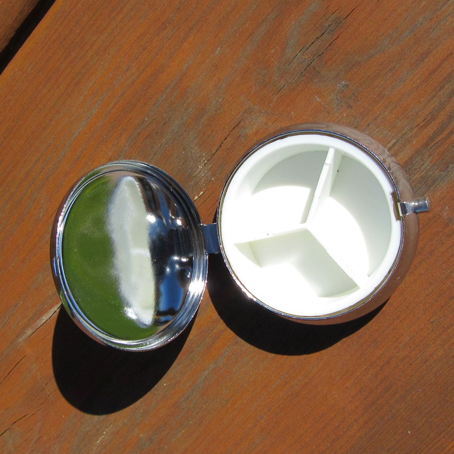 Runde Pillendose aus Edelstahl und Bernsteinintarsien