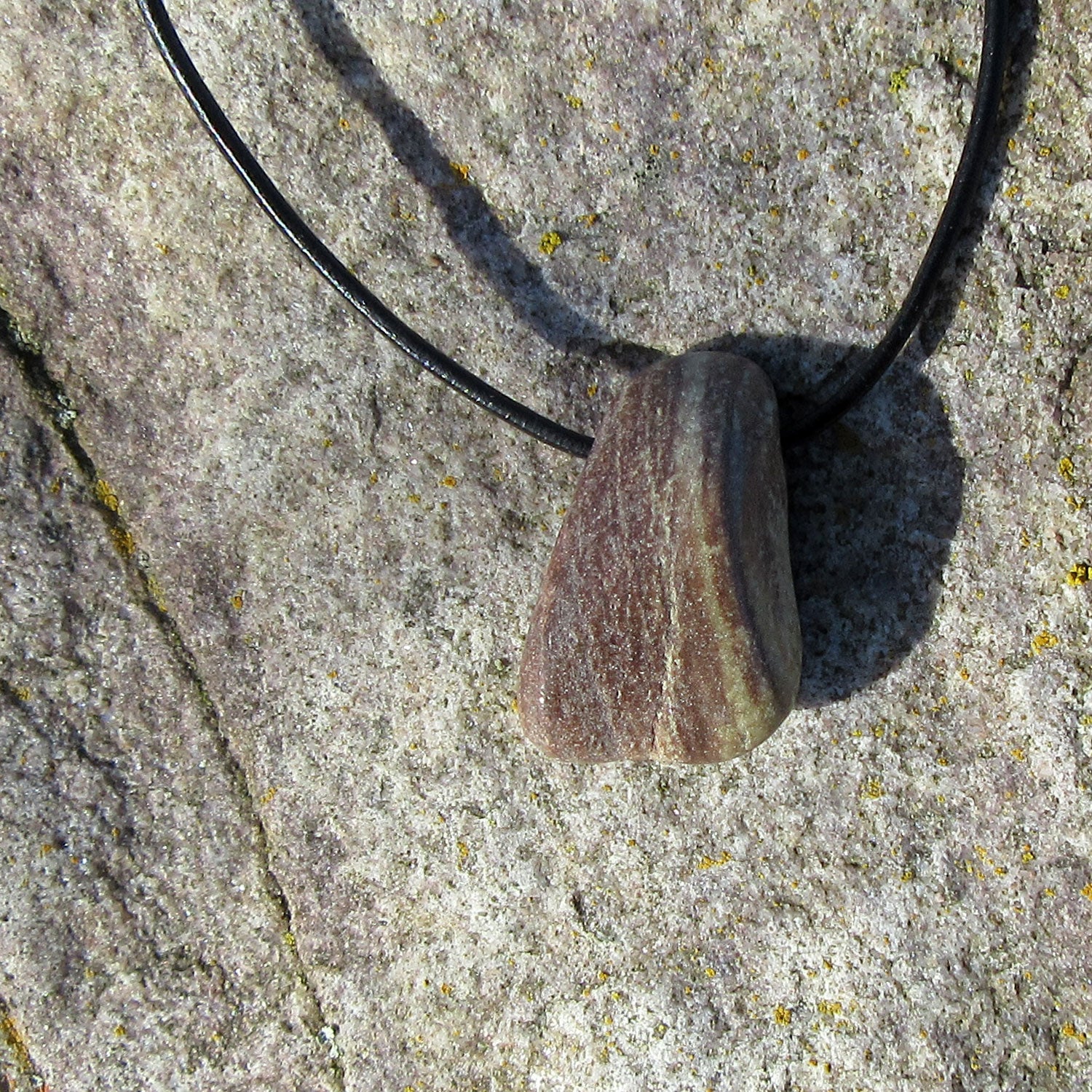 Polierter Sandstein am Lederband mit Schiebeknoten