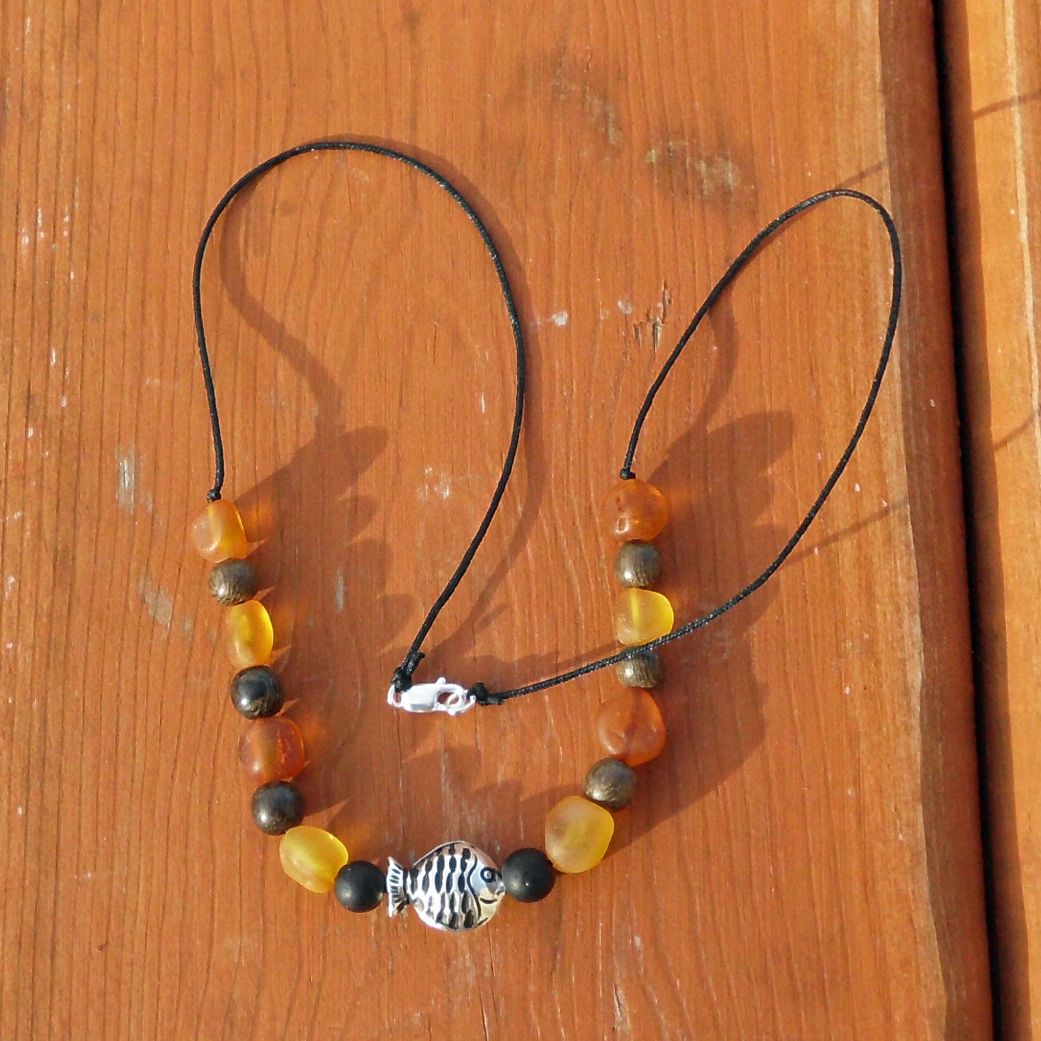 Nyloncollier mit unpolierten Bernsteinen und Silberfischchen