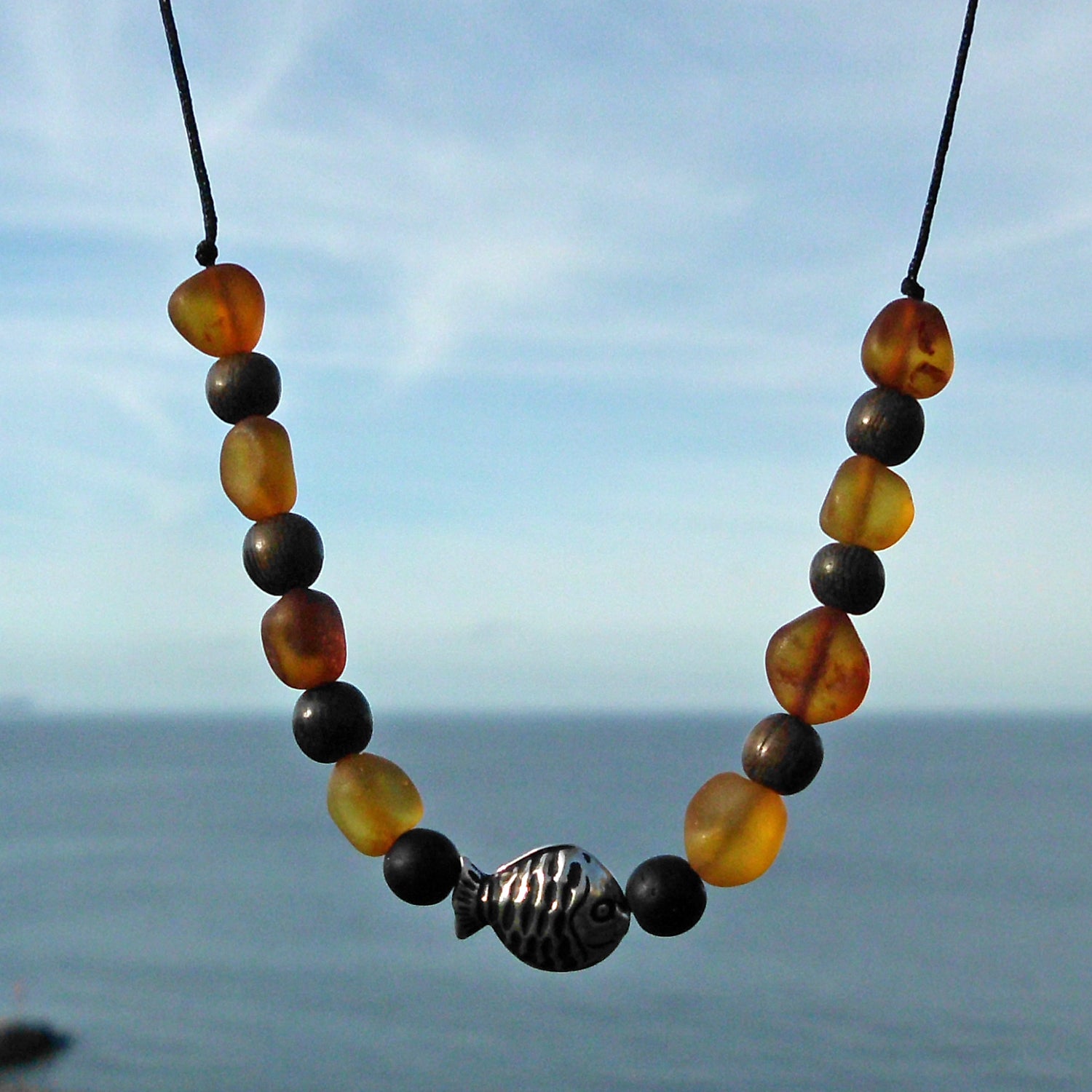 Nyloncollier mit unpolierten Bernsteinen und Silberfischchen