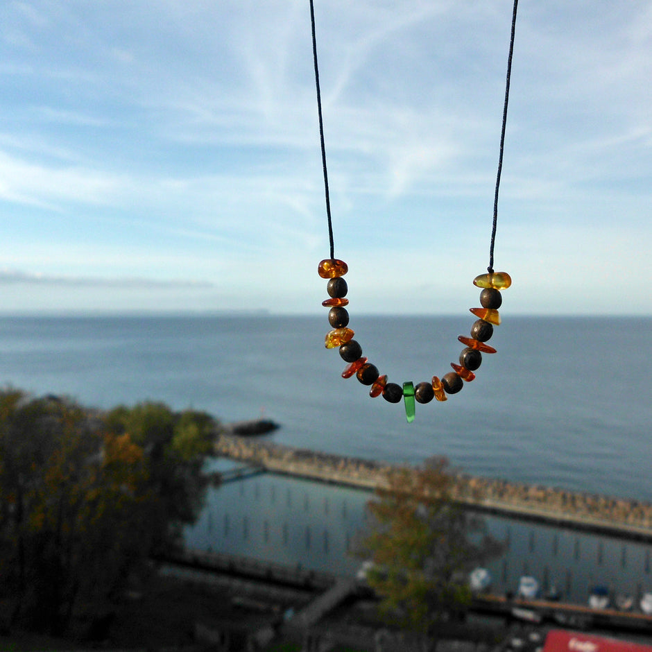 Einzelstück: Nyloncollier mit Bernstein und grünem Seeglas