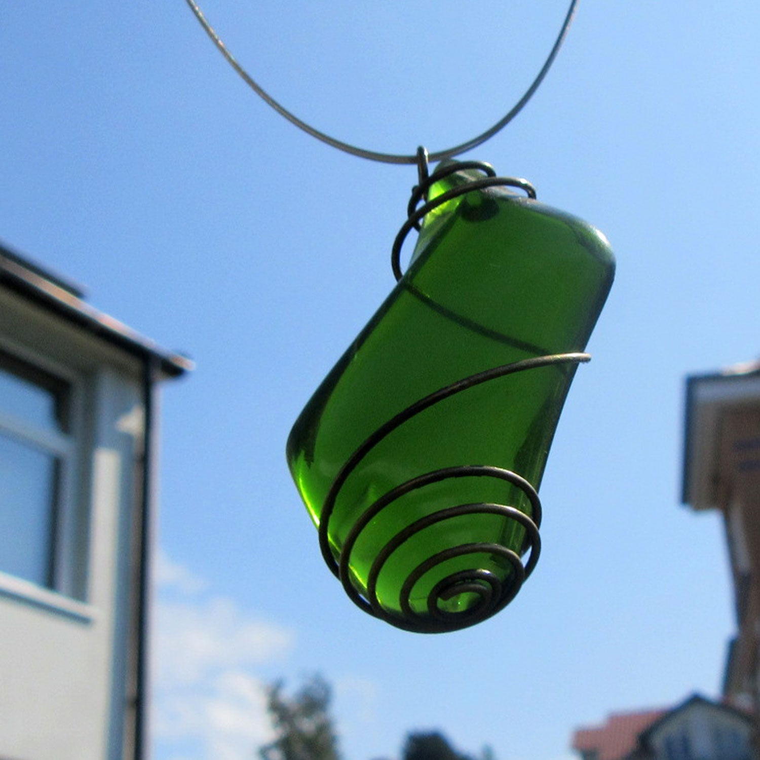 Grosser Anhänger aus grünem Seeglas in einer messingfarbenen Spirale